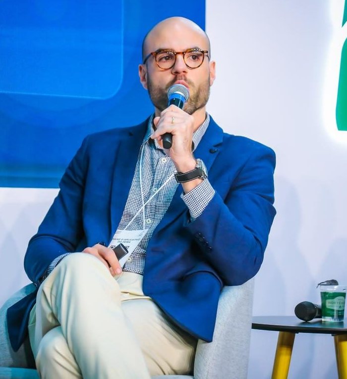 Bernardo Costa falando ao microfone em painel